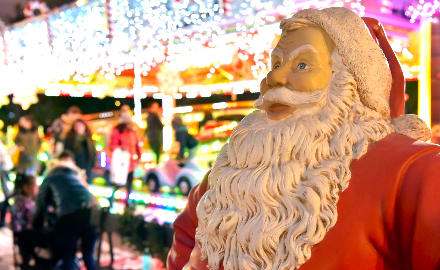 Photo de Père Noël devant les chalets de Noël