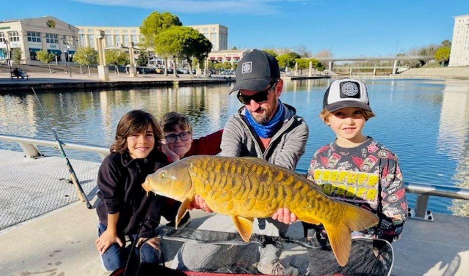 Baptiste Lucius et les élèves de l'Ecole de l'eau et de la pêche, montrant leur prise dans le Lez
