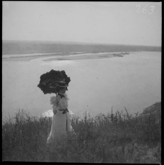 Paysage de rivière avec une femme à l'ombrelle