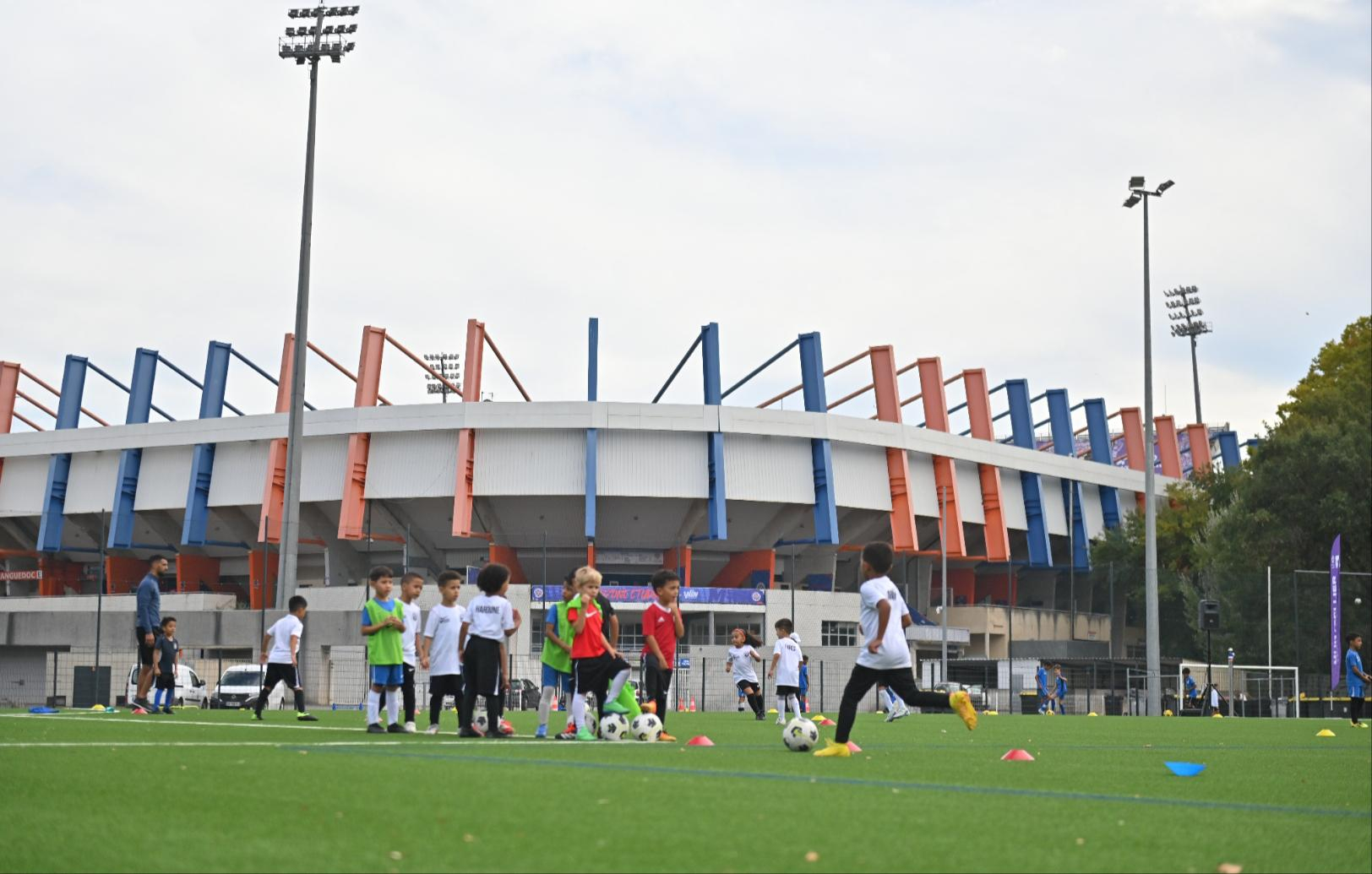 nouvelle pelouse synthétique enfants jouant au foot stade la Mosson en arrière-plan