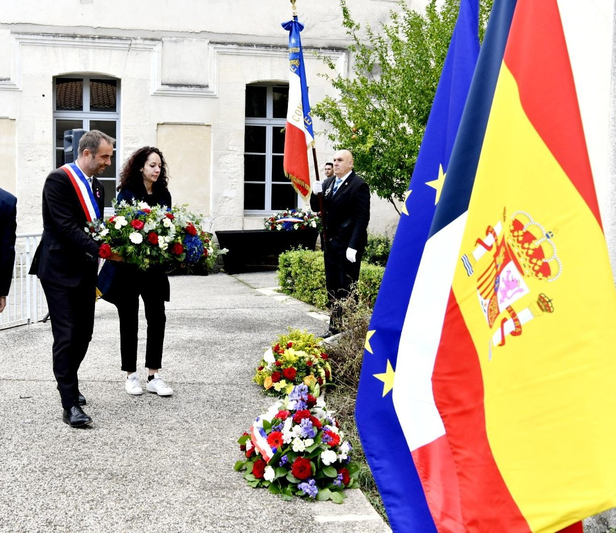 dépôt de gerbe devant la plaque commémorative en hommage à Elise et Henri Pinol.